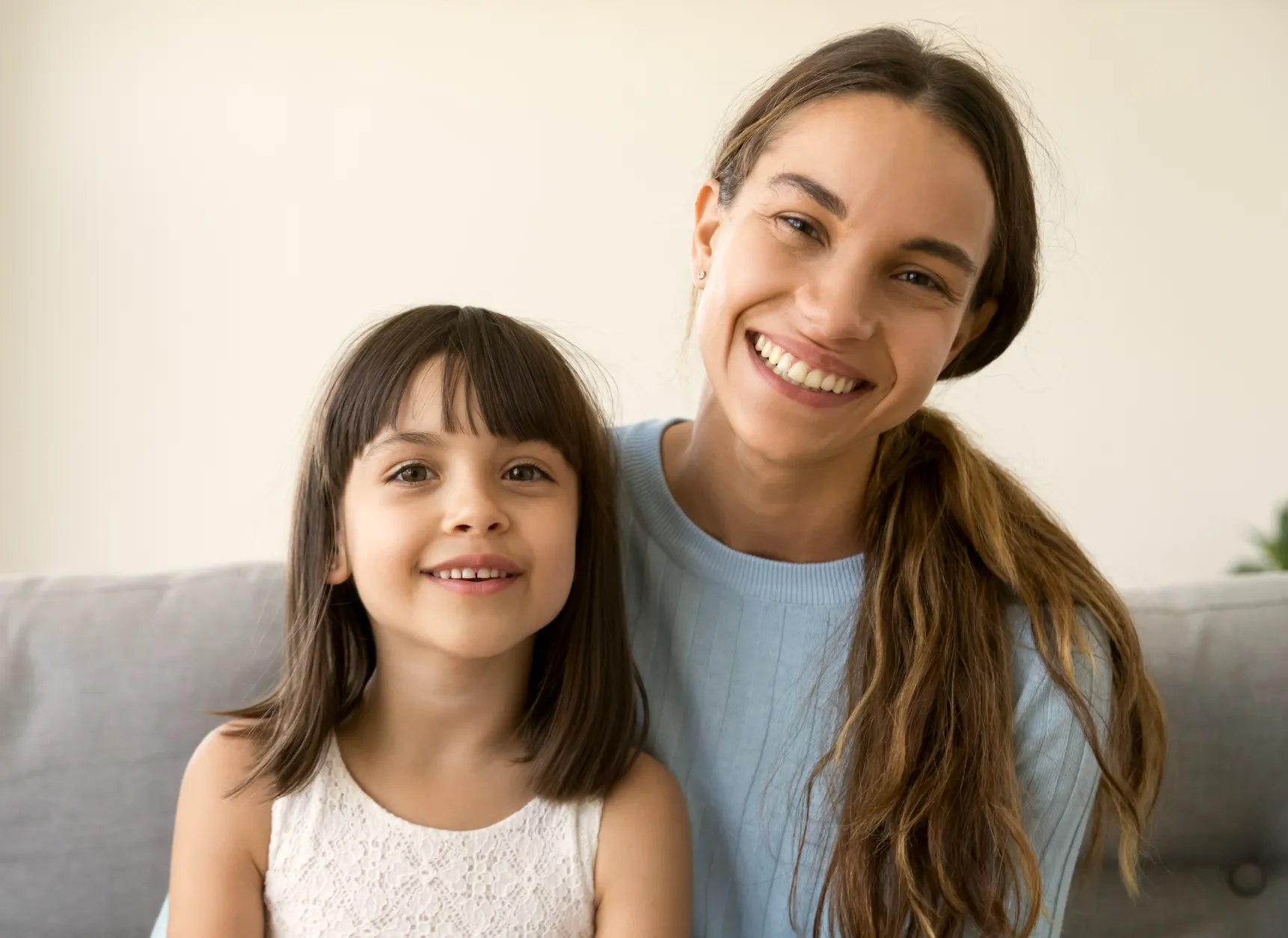 a woman and a little girl sitting on a couch