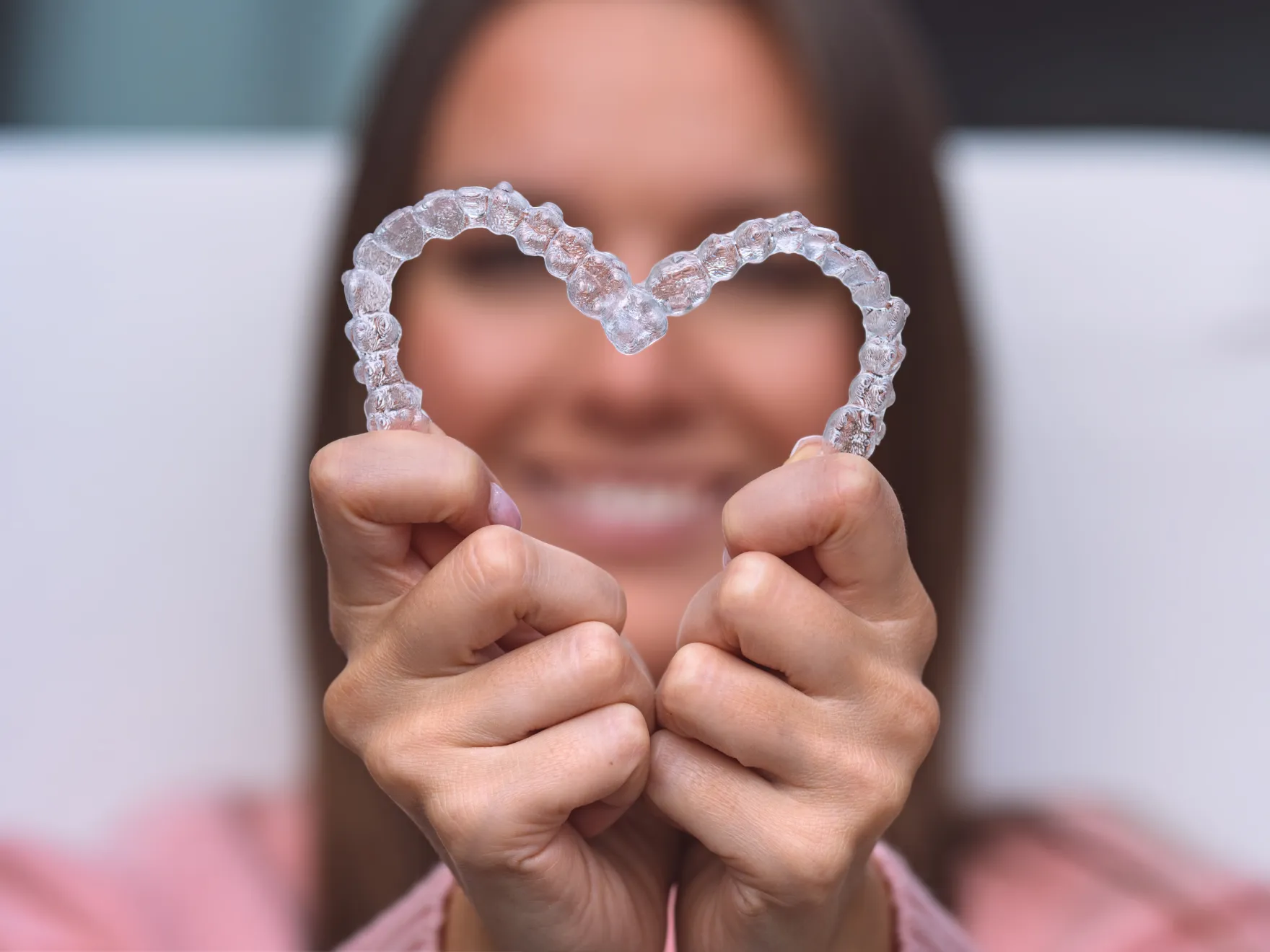 a woman holding a heart shaped object in front of her face
