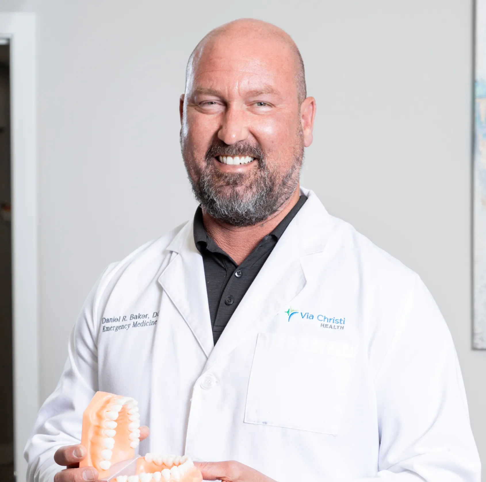 a man in a white lab coat holding a toothbrush