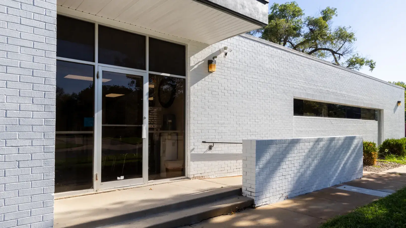 a white brick building with glass doors and windows