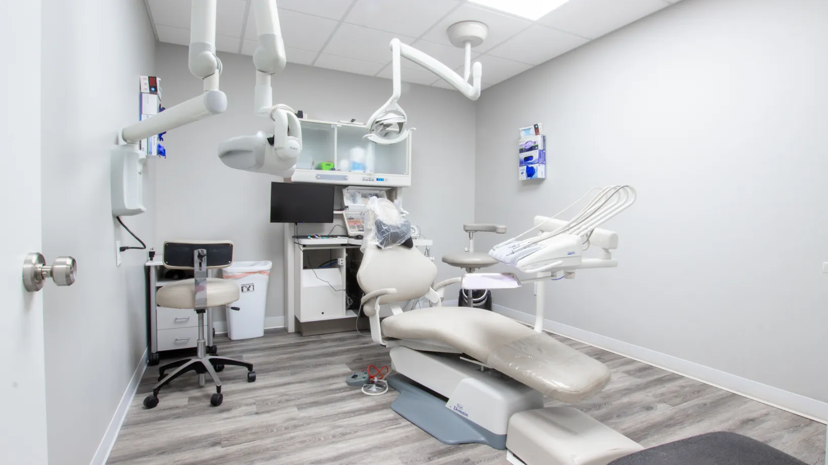 a dental office with white chairs and lights